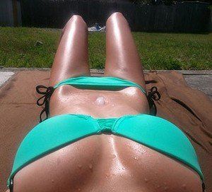 Gebräuntes Bikini Girl liegt im Bikini in der Sonne