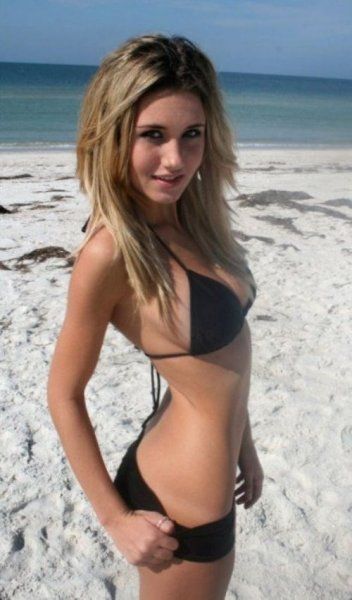 Süßes blondes Girl posiert im Bikini am Strand