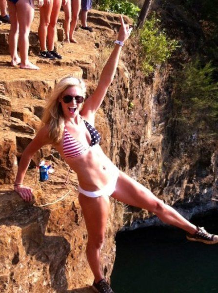 Blondes Girl mit USA Bikini posiert an gefährlicher Klippe