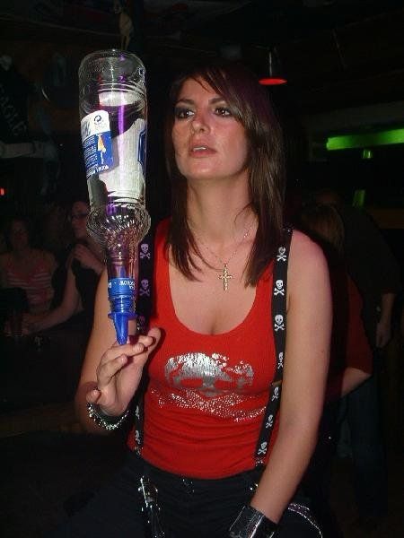 Girl balanciert Wodkaflasche auf der Hand