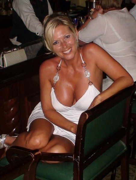 Blonde Milf mit großen Hupen sitzt an der Bar