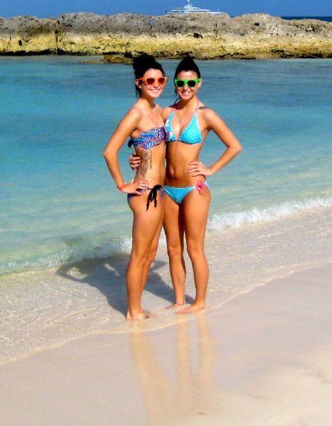 Zwei Girls stehen im Bikini am Strand